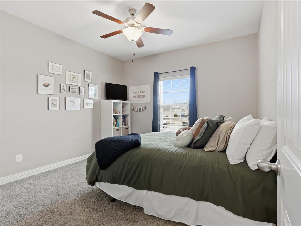 810 Chestnut Grove Drive Cleburne, TX 76033 - Photo 11 of 40 a bedroom with a bed and a chandelier