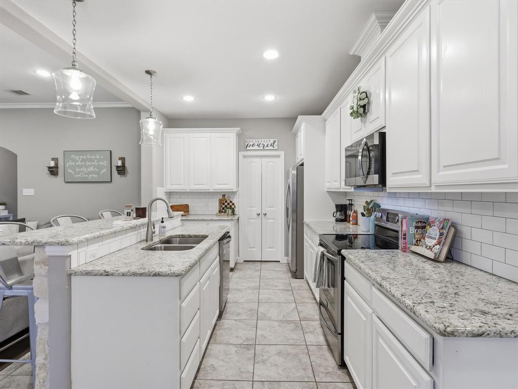 810 Chestnut Grove Drive Cleburne, TX 76033 - Photo 20 of 40 a kitchen with stainless steel appliances granite countertop a sink stove and cabinets