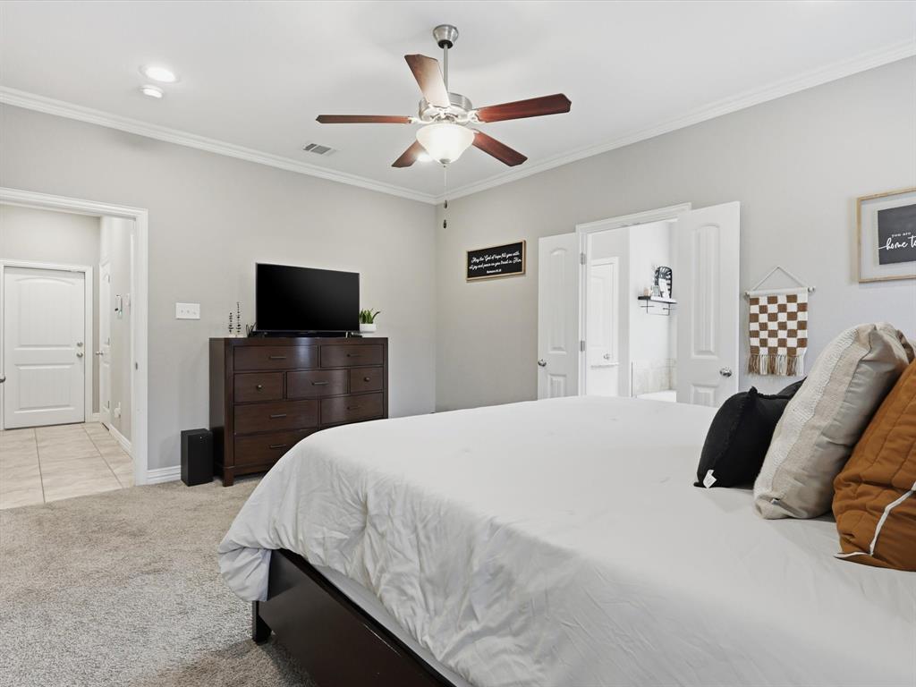 810 Chestnut Grove Drive Cleburne, TX 76033 - Photo 32 of 40 a bedroom with a bed and a flat screen tv