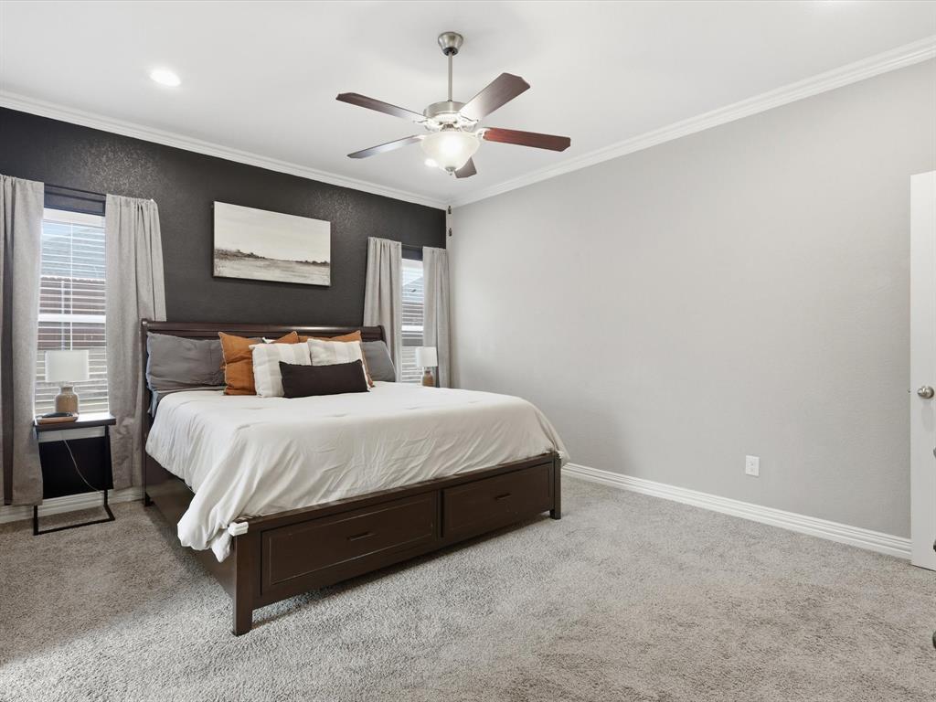 810 Chestnut Grove Drive Cleburne, TX 76033 - Photo 33 of 40 a bedroom with a large bed and a ceiling fan