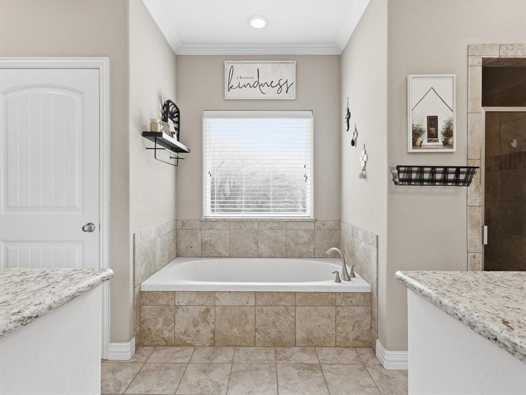 810 Chestnut Grove Drive Cleburne, TX 76033 - Photo 34 of 40 a spacious bathroom with a granite countertop tub sink and mirror