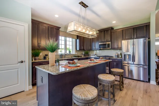 a kitchen with a sink stainless steel appliances and chandelier