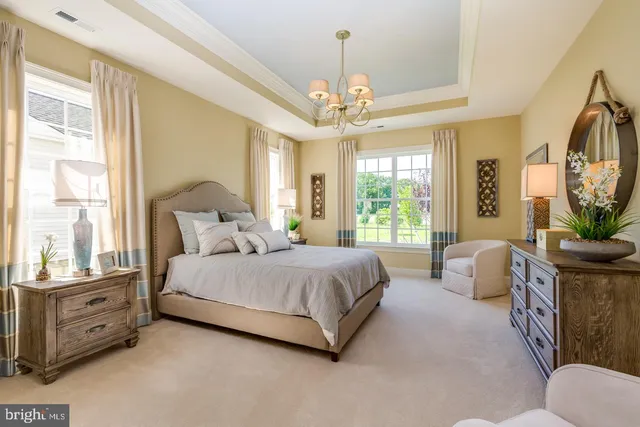 a spacious bedroom with a bed and a chandelier