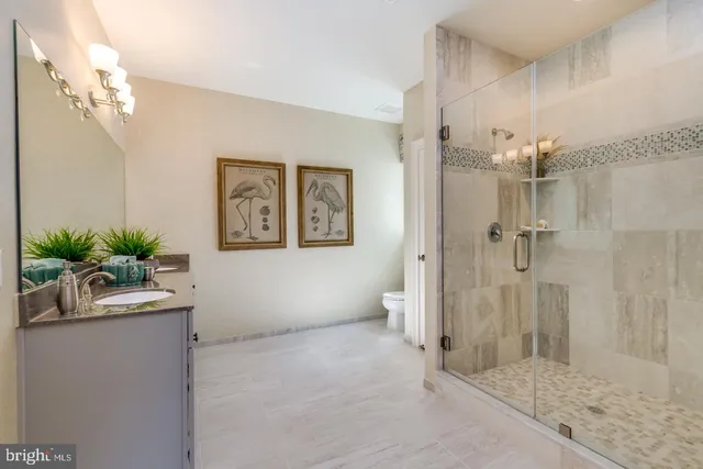 a bathroom with a granite countertop sink a mirror and a shower