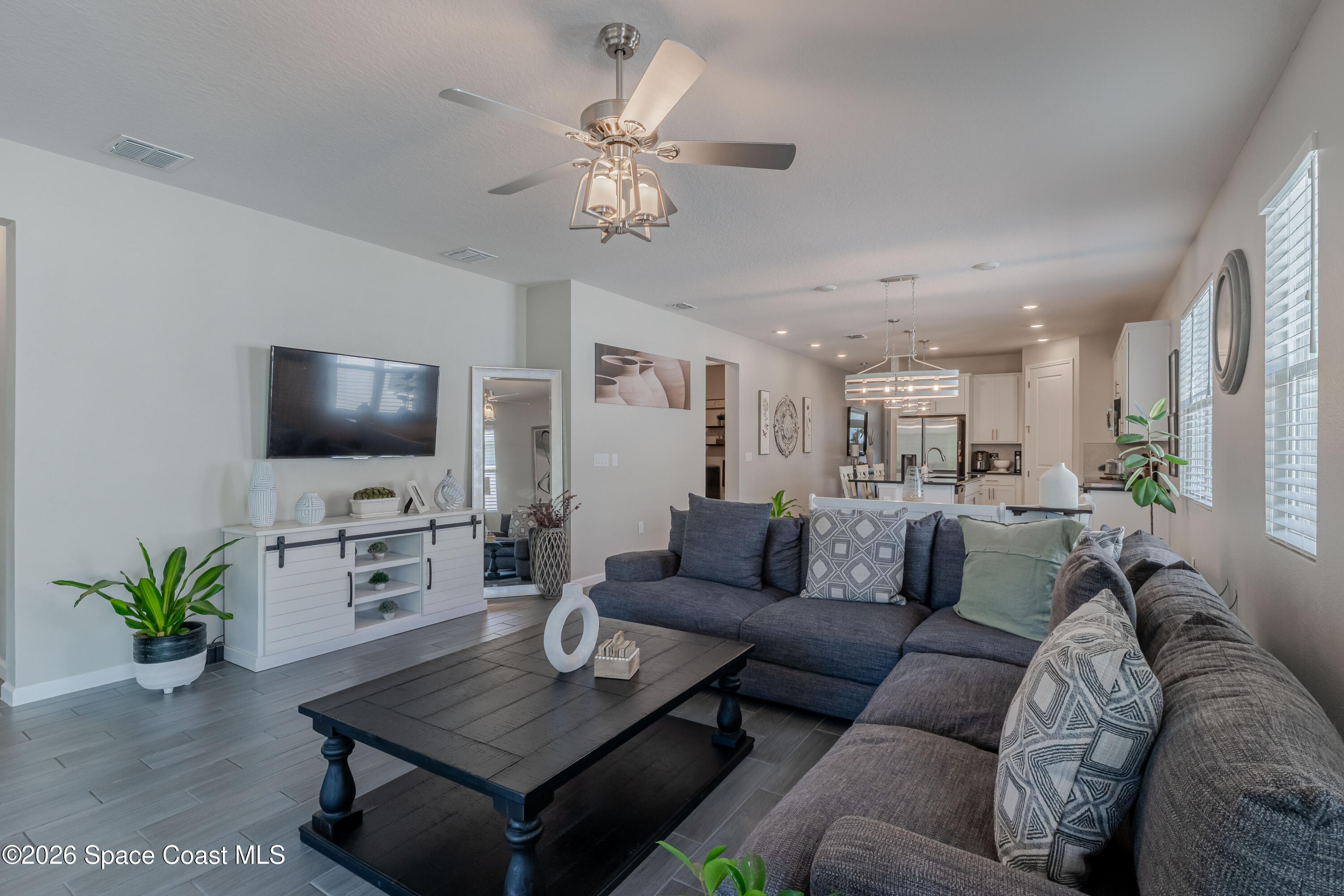 4342 Southern Vista Loop St. Cloud, FL 34772 - Photo 14 of 30 a living room with furniture a chandelier and a flat screen tv