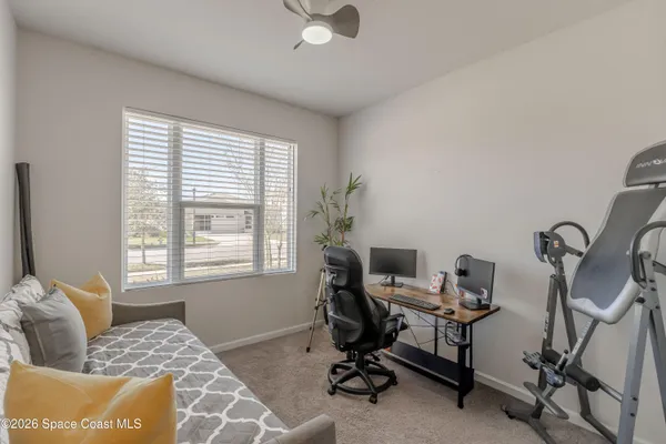 a view of a workspace with furniture and a window