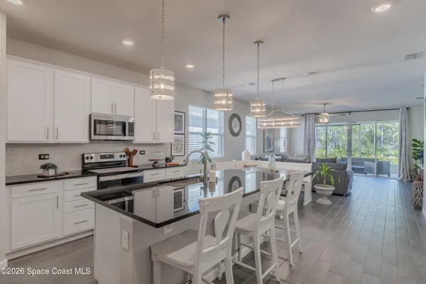 a kitchen with stainless steel appliances granite countertop a stove top oven a sink a stove and white cabinets
