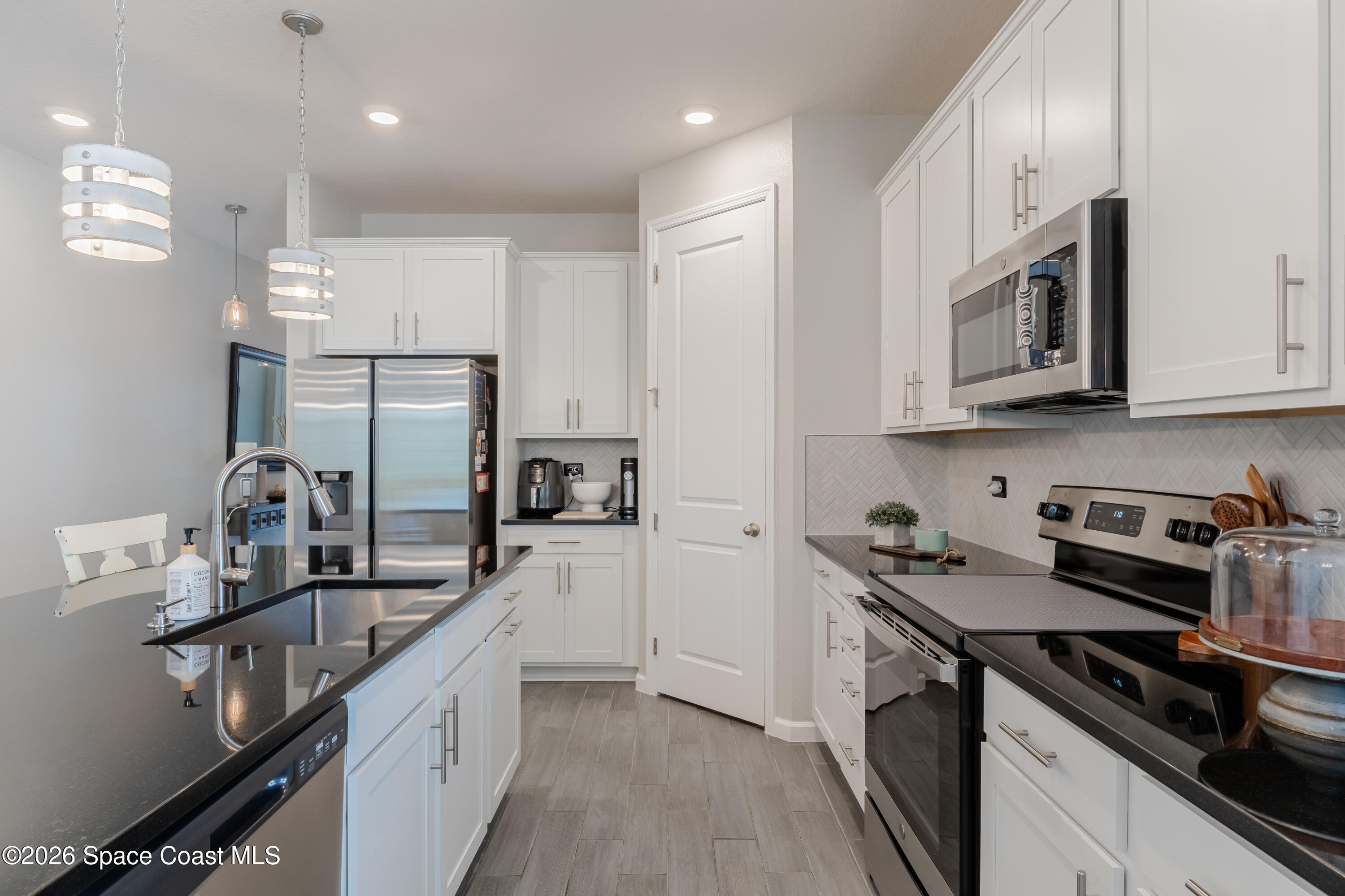 4342 Southern Vista Loop St. Cloud, FL 34772 - Photo 6 of 30 a kitchen with stainless steel appliances a sink stove and refrigerator
