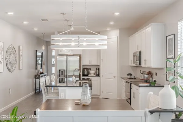 a kitchen with a dining table chairs and chandelier