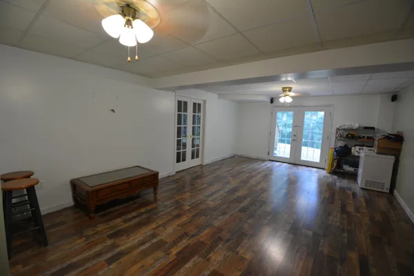 a view of a livingroom with a fireplace a chandelier fan and wooden floor