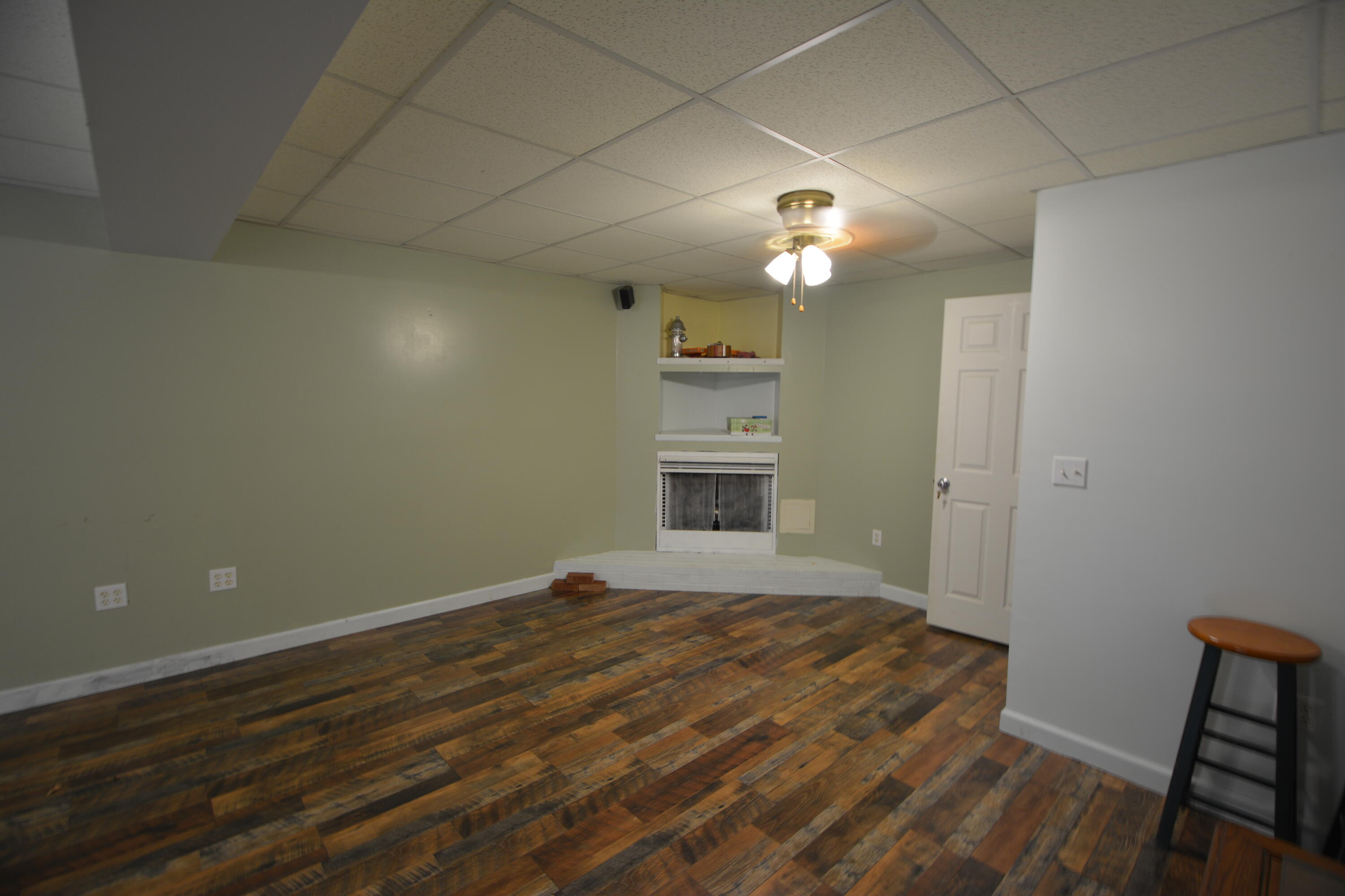 6880 Fork Mountain Road Rocky Mount, VA 24151 - Photo 19 of 22 a view of a livingroom with a fireplace a chandelier fan and wooden floor