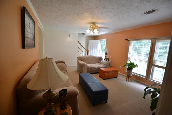 a living room with furniture chandelier and a large window