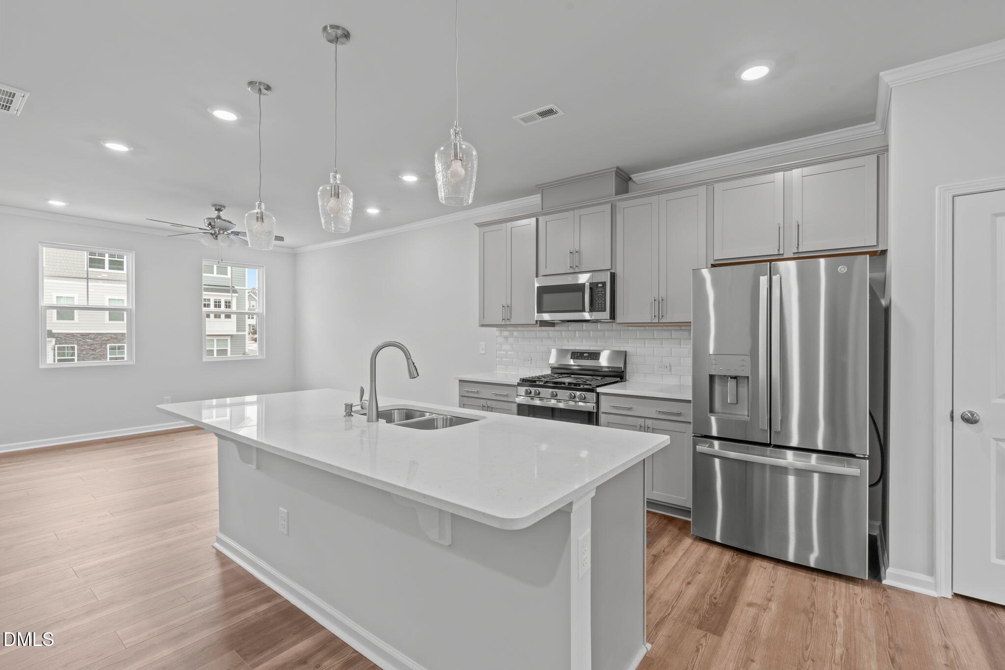 504 Light Oak Way Apex, NC 27539 - Photo 10 of 38 a kitchen with kitchen island a sink appliances a counter space and a window