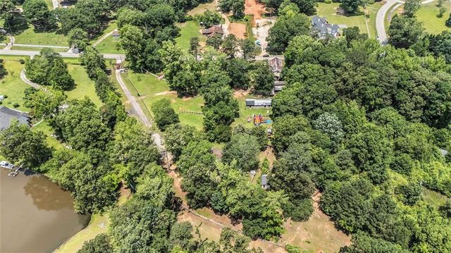 an aerial view of residential houses with outdoor space and trees