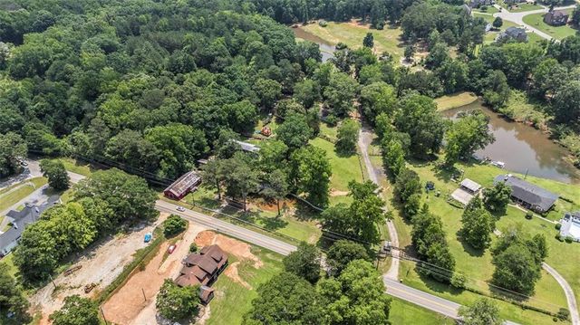 an aerial view of residential house with outdoor space and trees all around