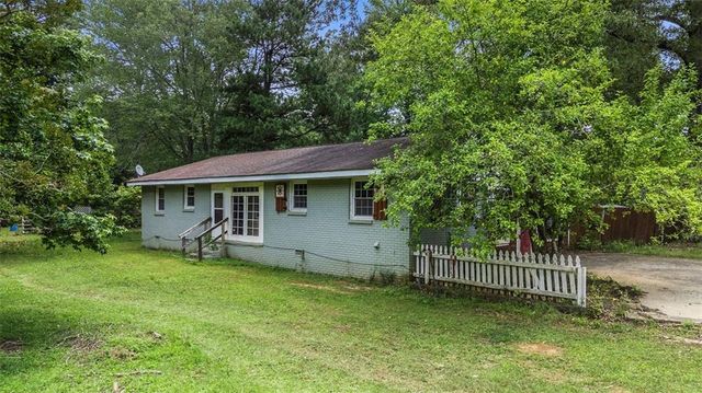 a view of a house with a yard and sitting area