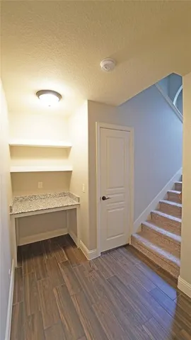 a view of a room with wooden floor and a rug