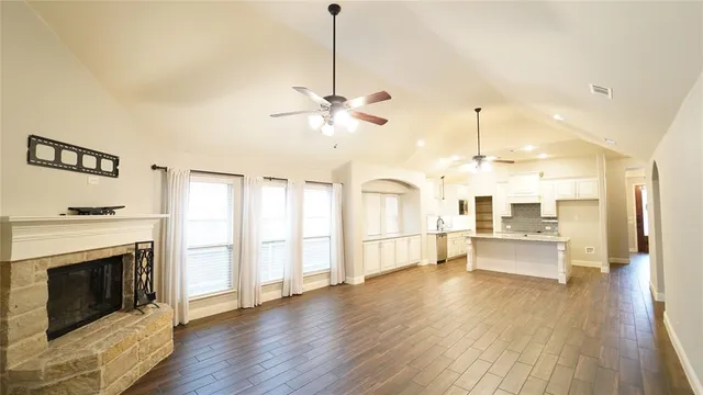 a open kitchen with white cabinets and wooden floor