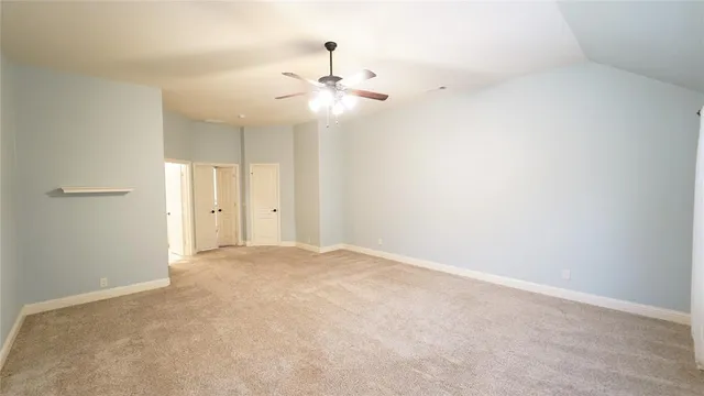 an empty room with chandelier fan and closet