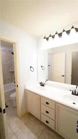 a bathroom with a double vanity sink a toilet and a shower