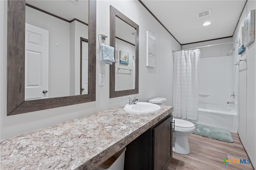 121 Fate Court Kyle, TX 78640 - Photo 13 of 23 a bathroom with a granite countertop sink toilet and shower