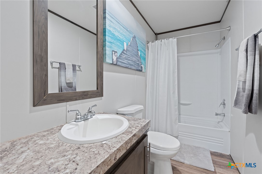121 Fate Court Kyle, TX 78640 - Photo 16 of 23 a bathroom with a granite countertop sink toilet and shower