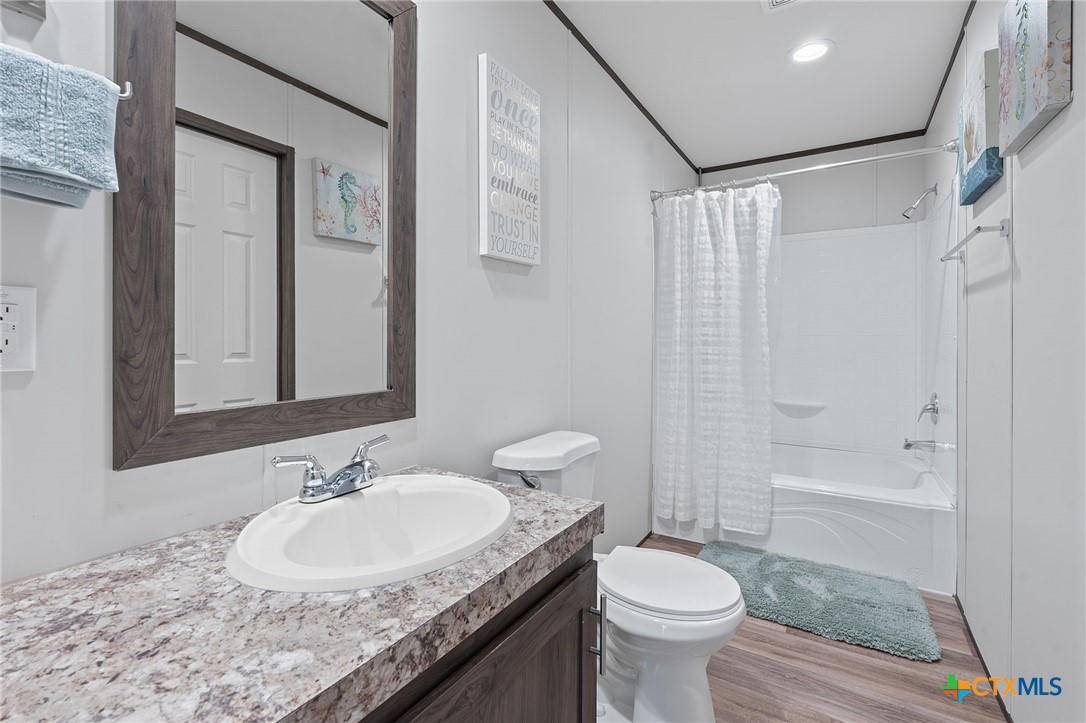 121 Fate Court Kyle, TX 78640 - Photo 18 of 23 a bathroom with a granite countertop sink toilet and shower