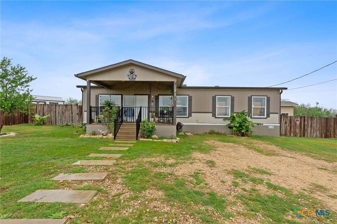 121 Fate Court Kyle, TX 78640 - Photo 2 of 23 a patio with a table and chairs under an umbrella