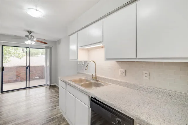 a kitchen with a sink cabinets and wooden floor