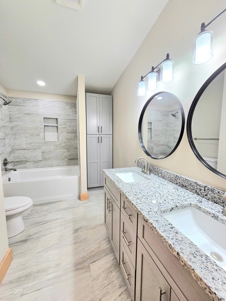 2417 Mobile Road McCaysville, GA 30555 - Photo 9 of 17 a bathroom with a granite countertop toilet a sink and a mirror