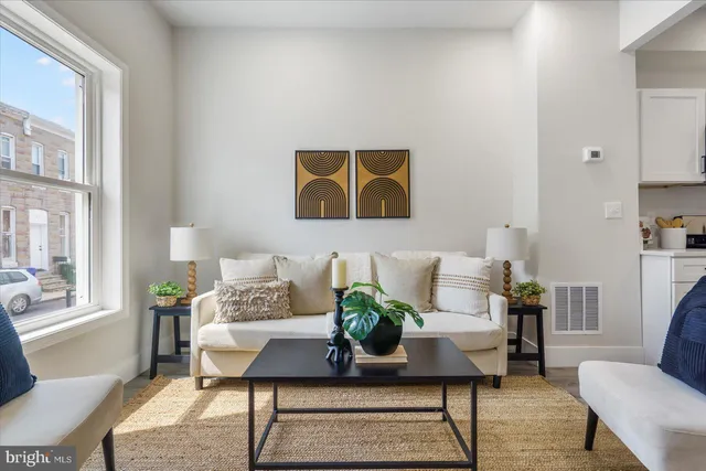 a living room with furniture and a painting on the wall