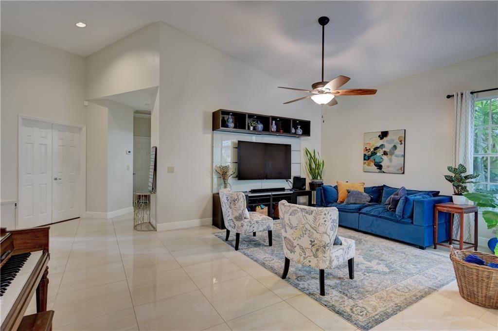 8171 Hampton Wood Drive Boca Raton, FL 33433 - Photo 51 of 56 a living room with furniture a dining table and a fireplace