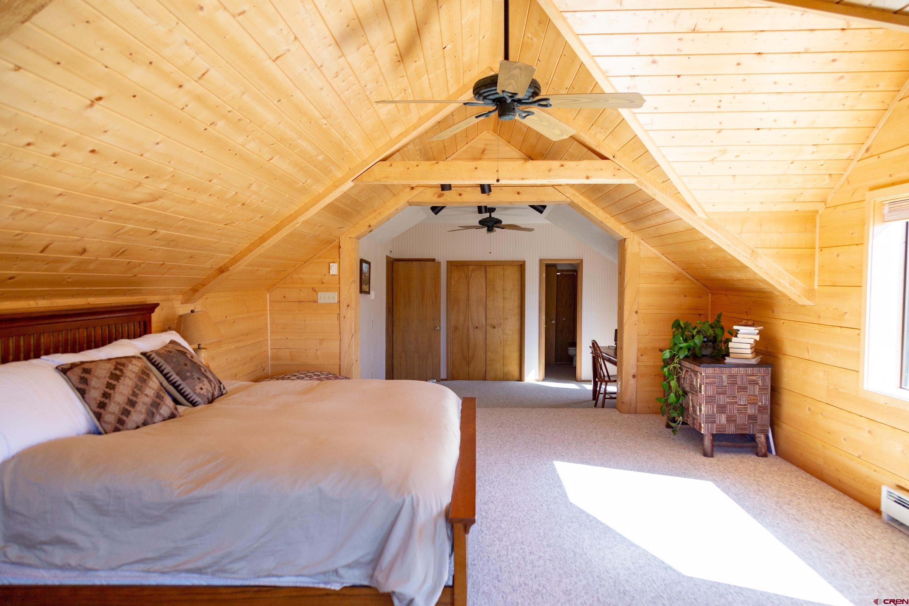 516 Rio Grande Court Creede, CO 81130 - Photo 11 of 33 a bedroom with a bed and a chandelier