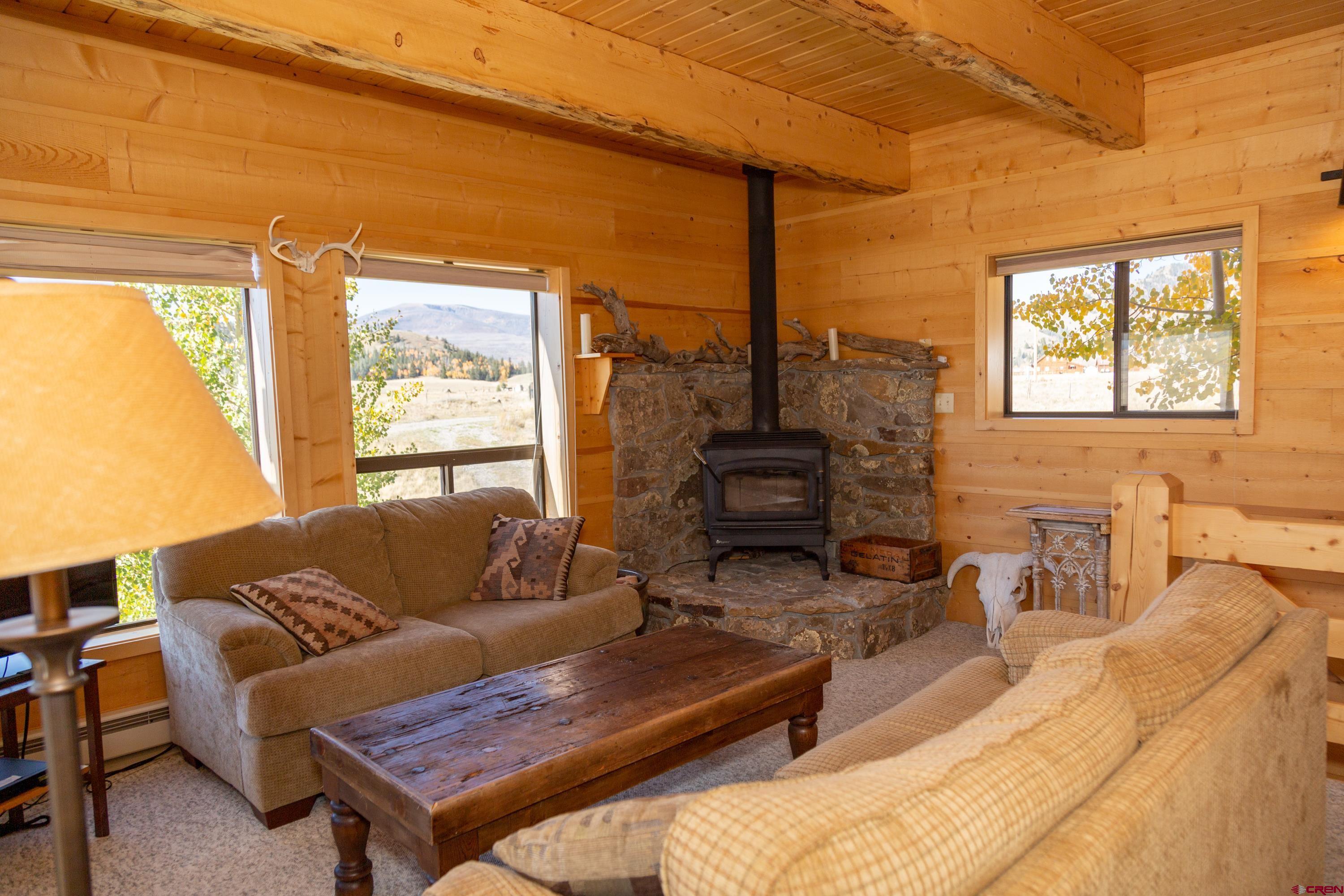 516 Rio Grande Court Creede, CO 81130 - Photo 14 of 33 a living room with furniture a large window and a fireplace