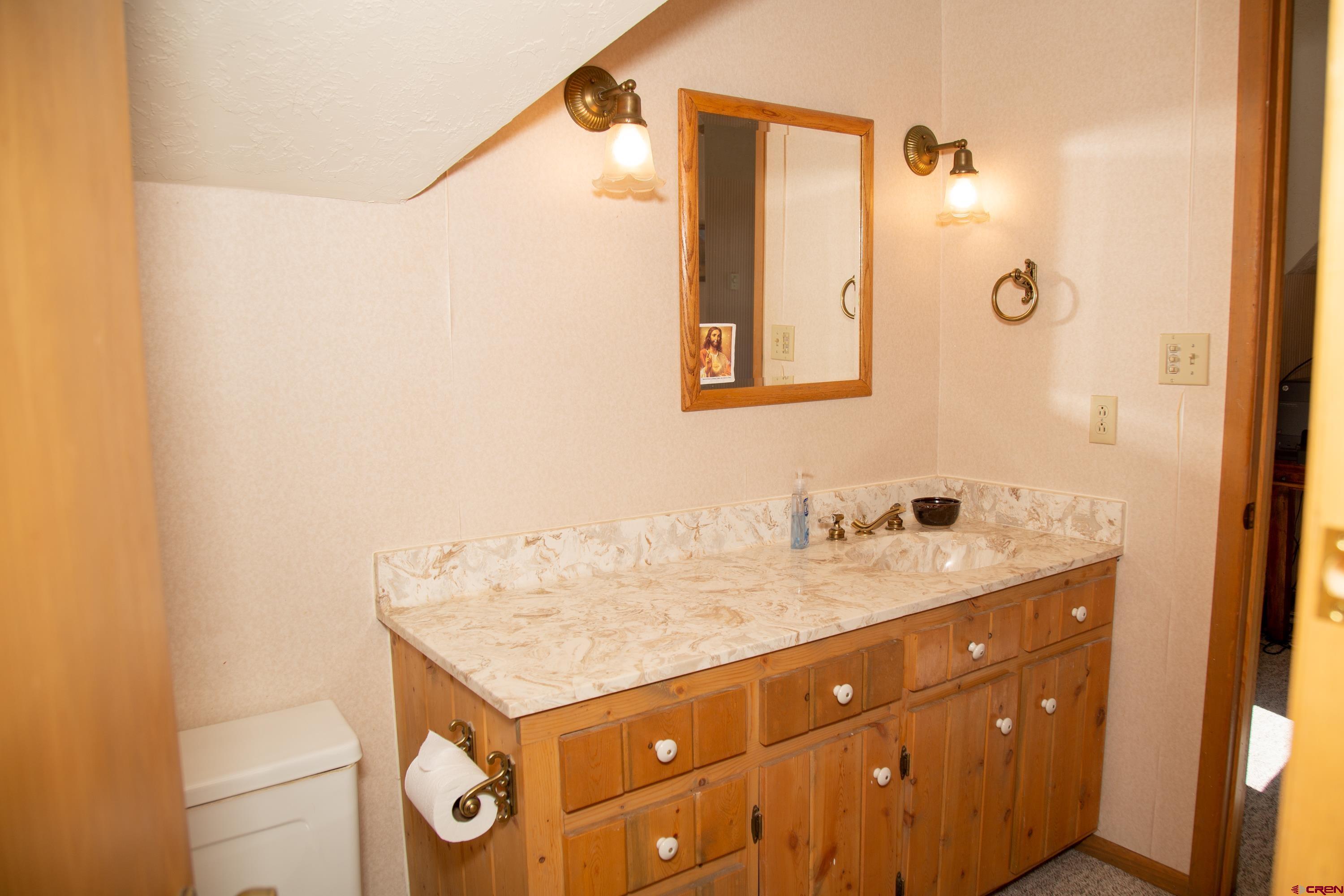 516 Rio Grande Court Creede, CO 81130 - Photo 15 of 33 a bathroom with a granite countertop sink and a mirror