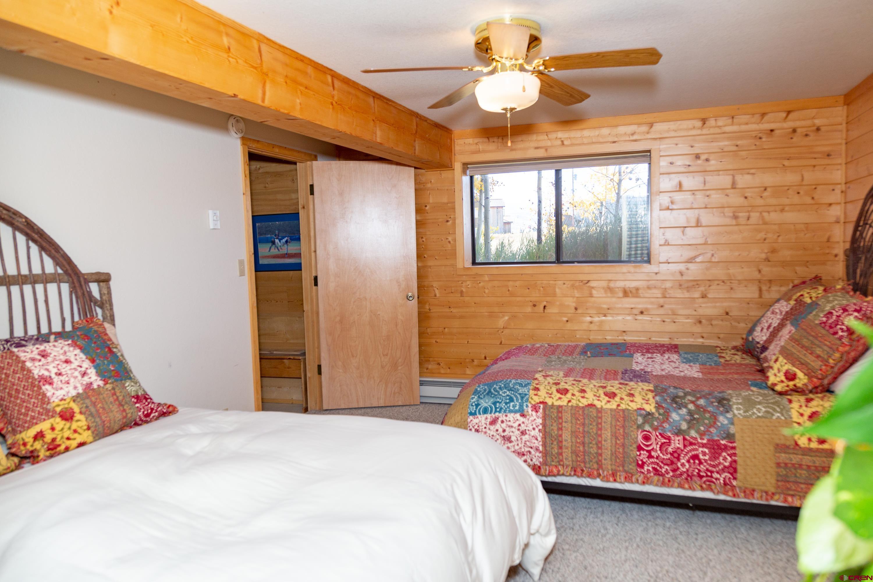 516 Rio Grande Court Creede, CO 81130 - Photo 19 of 33 a bedroom with a bed and a chandelier