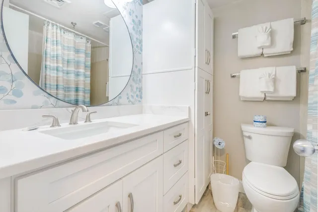 a bathroom with a sink a toilet and a mirror