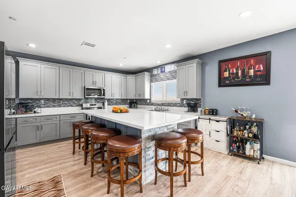 a kitchen with granite countertop a sink and chairs