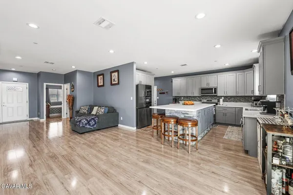 a kitchen that has a lot of cabinets a sink and wooden floor