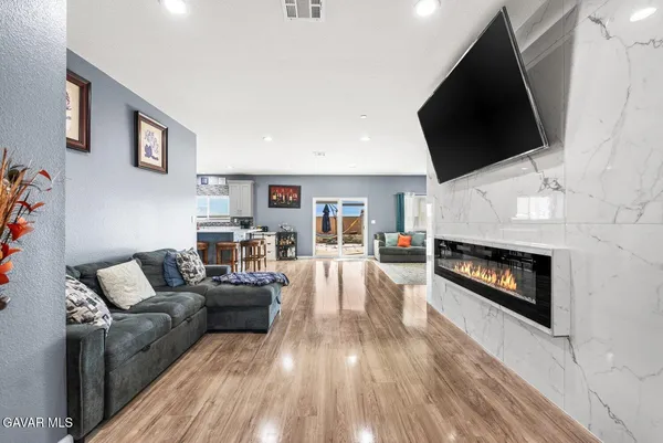 a living room with furniture a flat screen tv and a fireplace