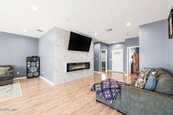 a kitchen with stainless steel appliances kitchen island granite countertop a sink a stove a refrigerator cabinets and chairs