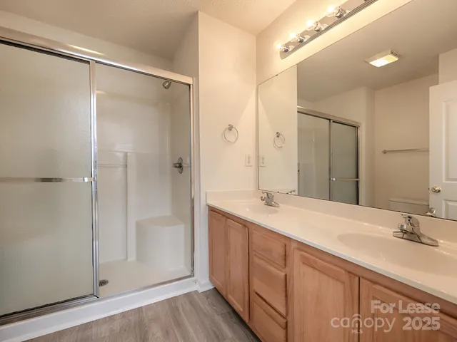 a bathroom with a double vanity sink mirror and shower