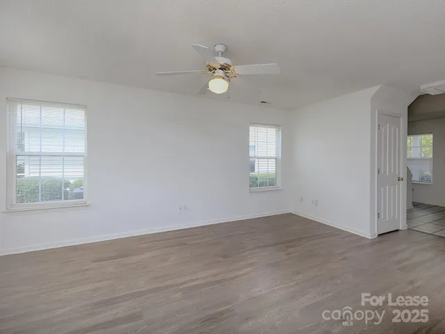 an empty room with wooden floor window and closet area