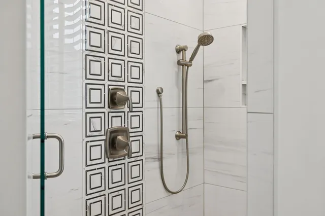 a bedroom with a bed chandelier and a window