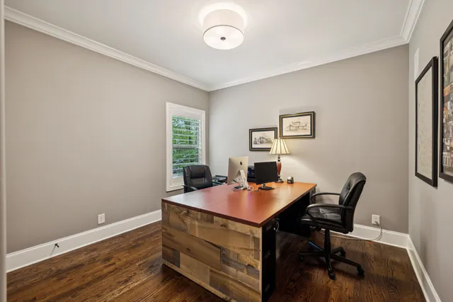 a living room with furniture a wooden floor and a clock