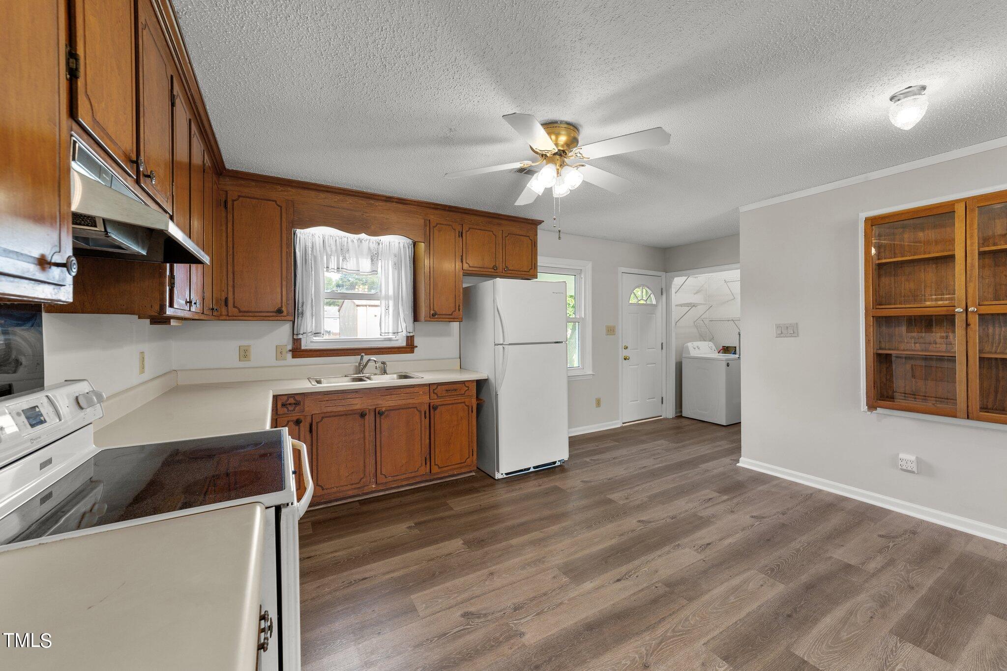 4868 Buffalo Road Selma, NC 27576 - Photo 11 of 48 a kitchen with a refrigerator a sink dishwasher a stove and a microwave oven