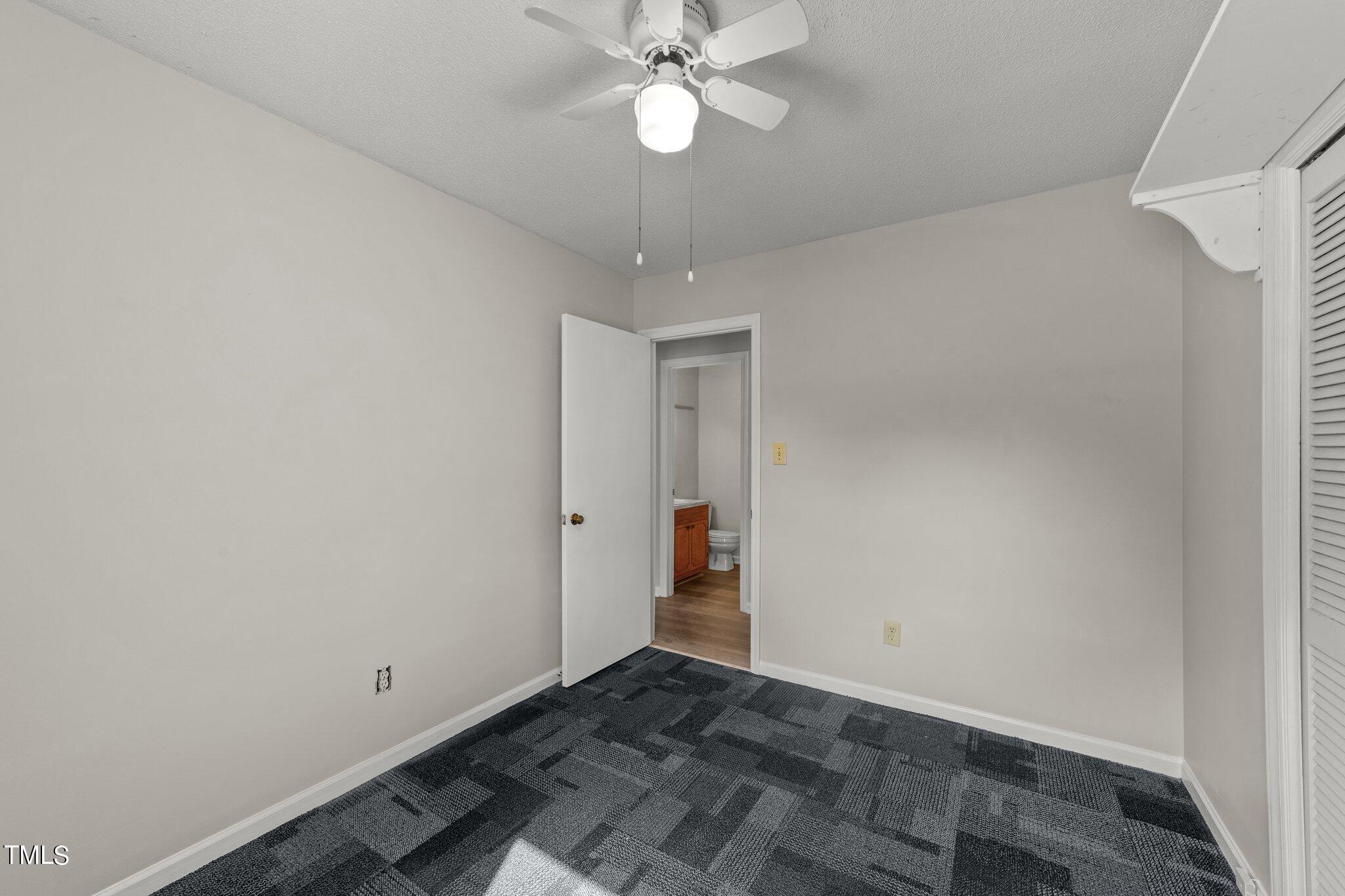 4868 Buffalo Road Selma, NC 27576 - Photo 19 of 48 an empty room with closet and a chandelier fan