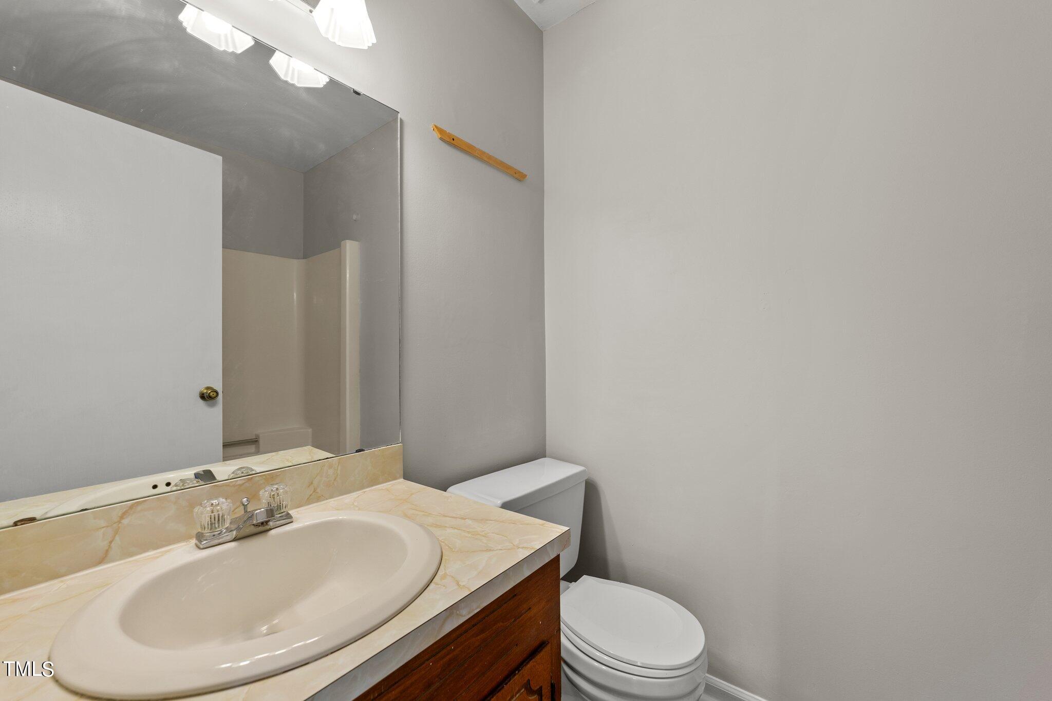 4868 Buffalo Road Selma, NC 27576 - Photo 25 of 48 a bathroom with a sink a toilet and vanity