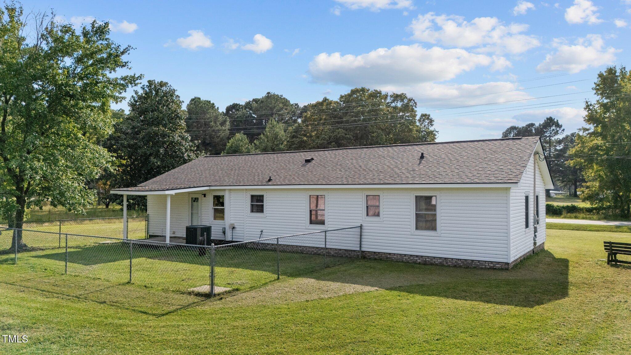 4868 Buffalo Road Selma, NC 27576 - Photo 32 of 48 a view of a house with swimming pool and a yard