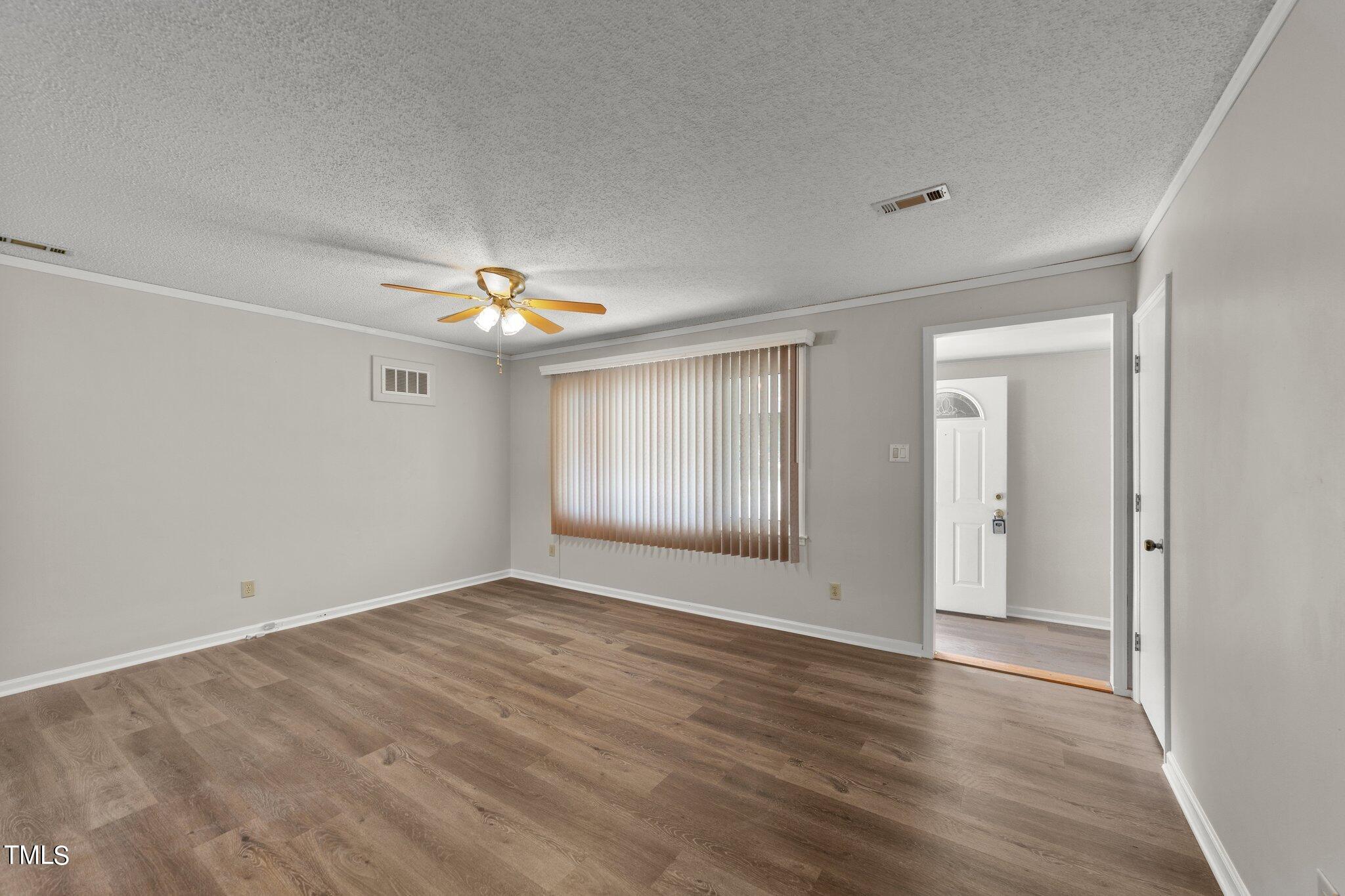4868 Buffalo Road Selma, NC 27576 - Photo 9 of 48 a view of an empty room with window and wooden floor
